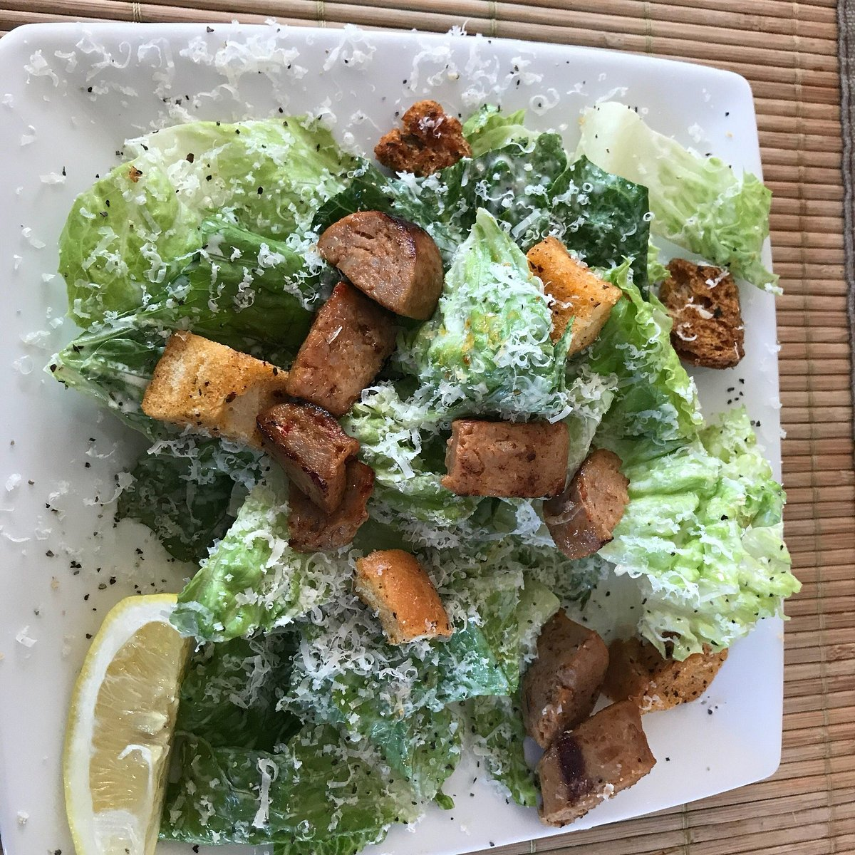 Caesar salad with grilled chicken, croutons, shaved parmesan and a lemon wedge