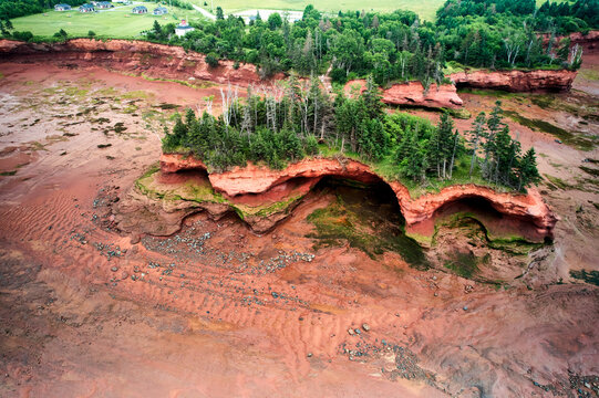 Aerial view of red sandstone sea caves and cliffs on the Minas Basin at low tide