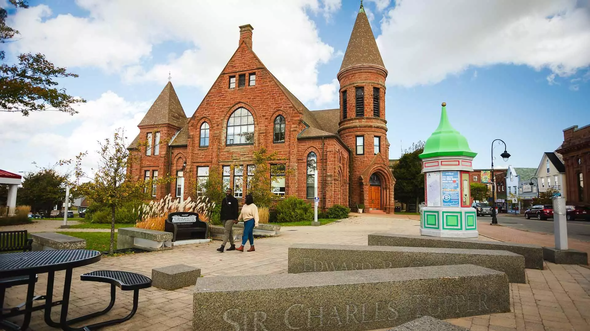 Historic red sandstone building with a green-domed kiosk on a town square near Joggins