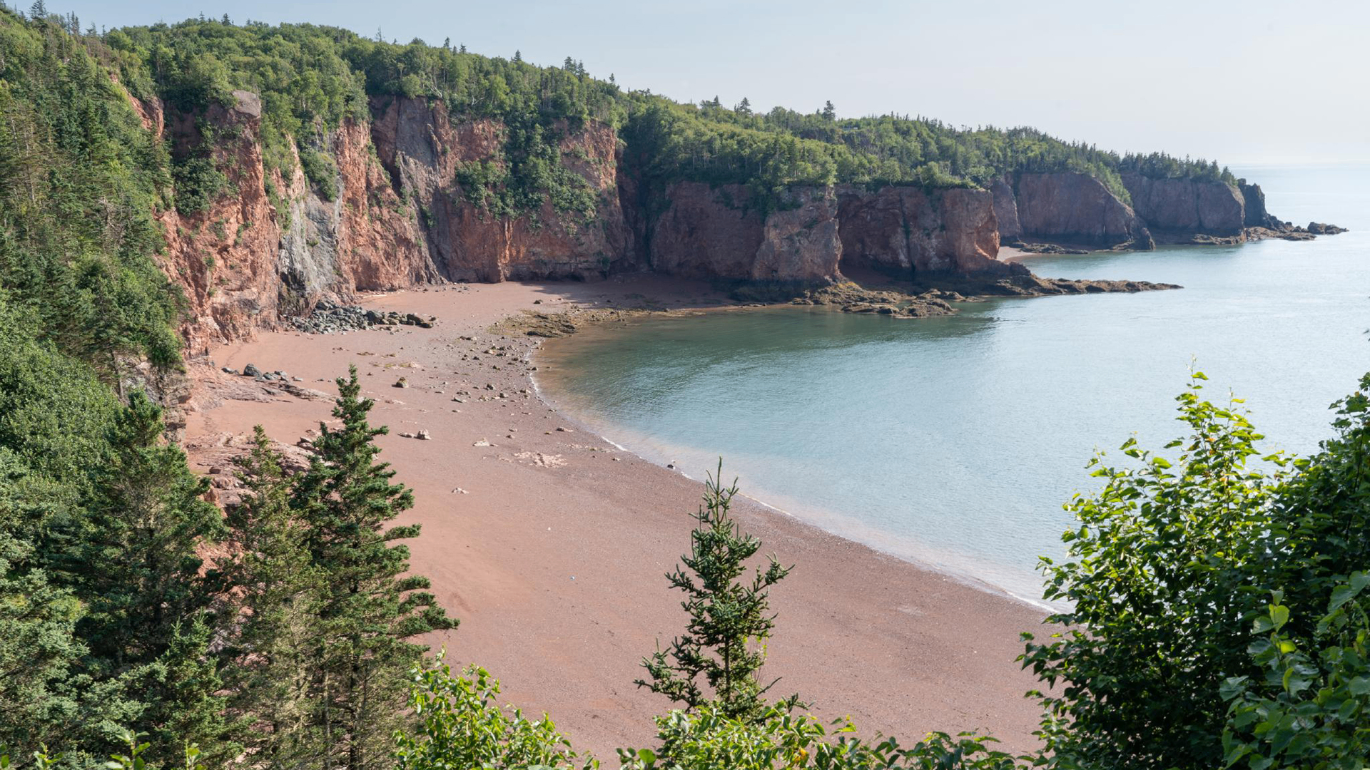 Cape Chignecto Provincial Park coastline with red cliffs, sandy beach, and turquoise water