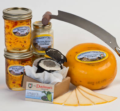 Assortment of That Dutchman's Farm gouda cheeses, hot pepper jelly, and crackers with a cheese knife