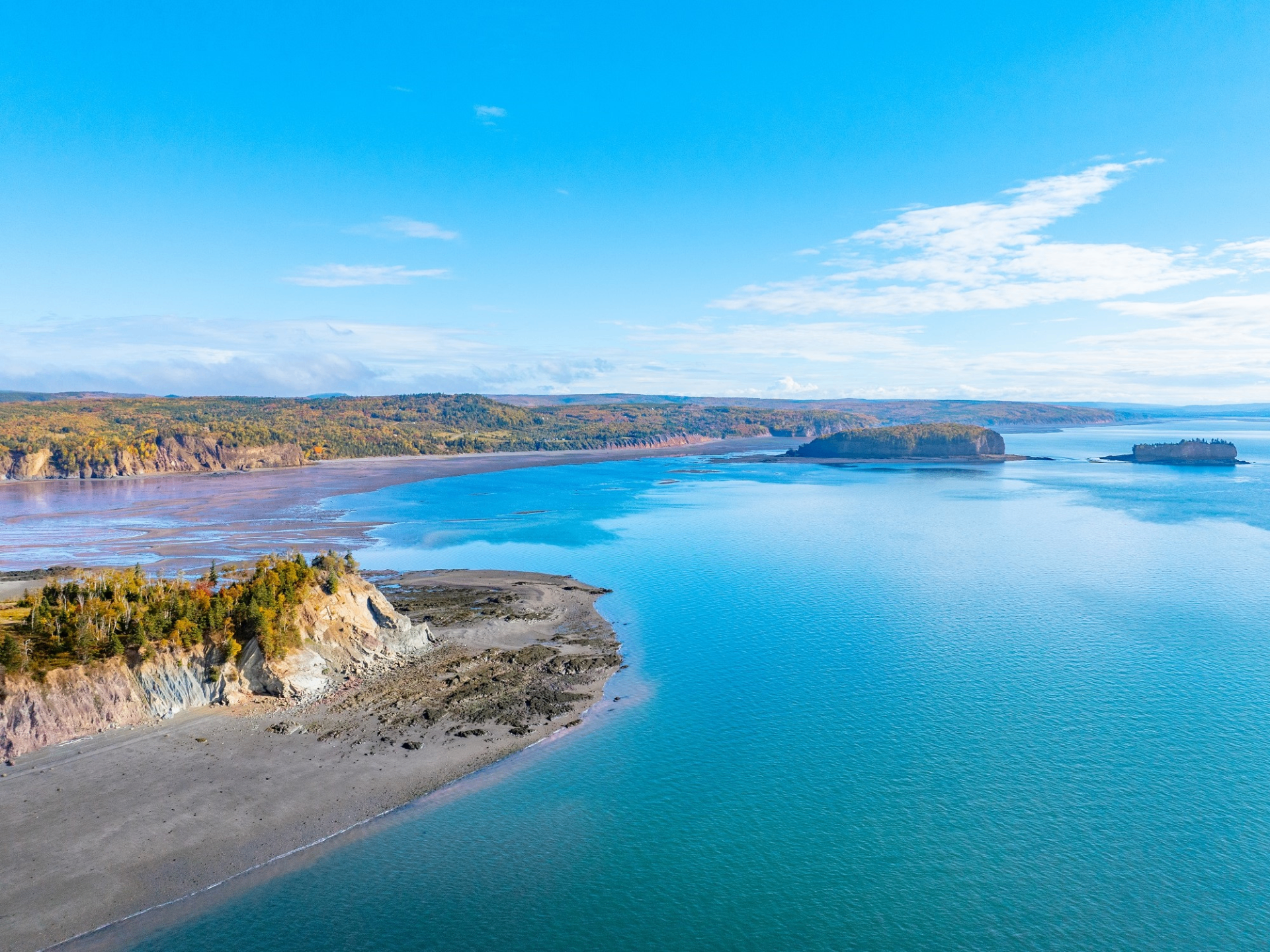 Fundy National Park coastline with sandy beaches, forested cliffs, and turquoise Bay of Fundy water