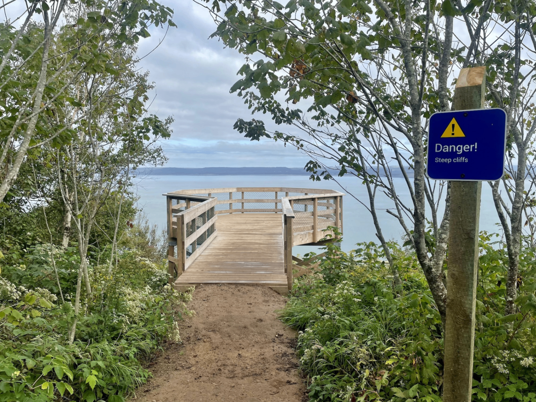 Wooden viewing platform at Cape Split with a blue Danger Steep Cliffs sign