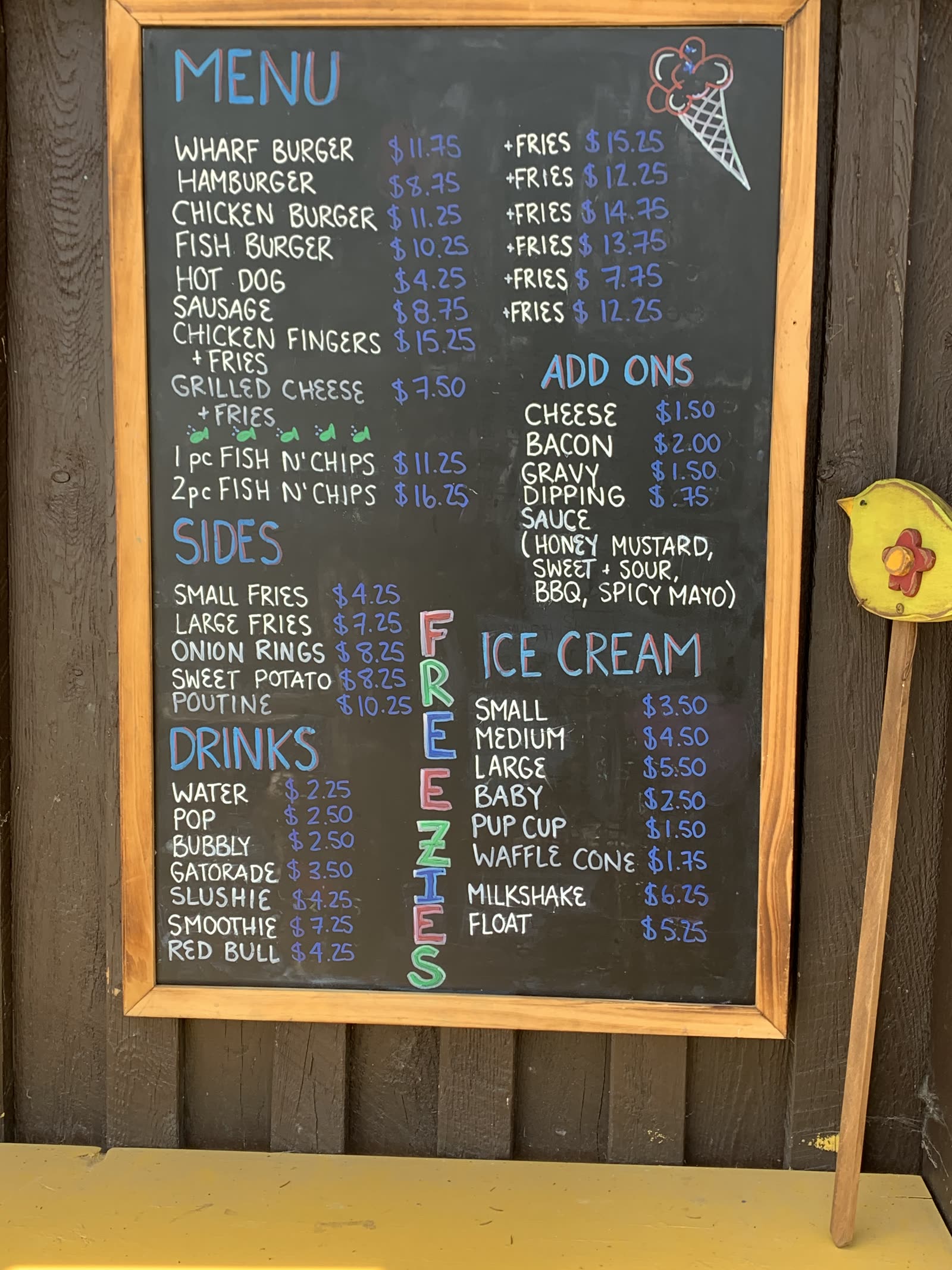 Chalkboard menu at Tide's In listing burgers, fish and chips, sides, drinks and ice cream with prices